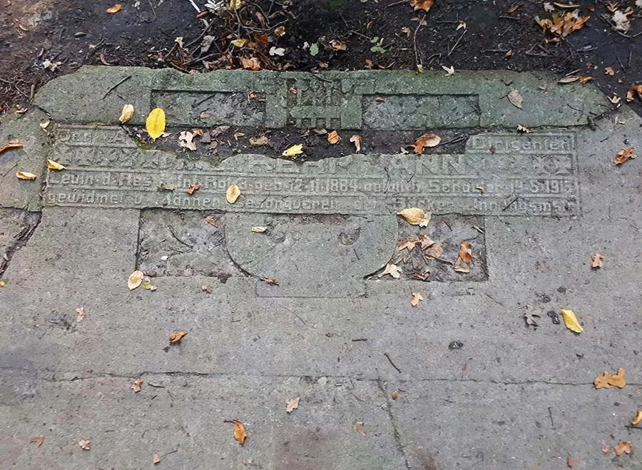 Мемориальная плита, вросшая в землю в Ашманн парке